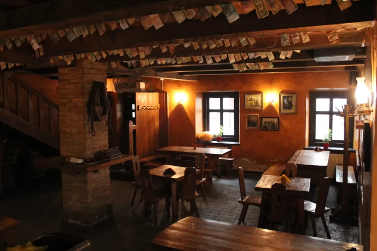 Banknotai iš viso pasaulio, sukabinti ant medinių sijų virš stalų